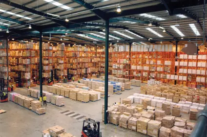 Inland warehouse interior with pallet racking and forklifts