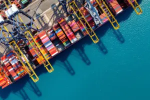 Aerial view of a container ship berthed under gantry cranes at a port terminal